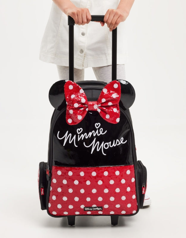 Child holding Smiggle Minnie Mouse trolley backpack with red polka-dot bow and ears